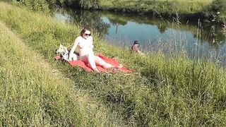 Wild beach. Sexy MILF Platinum naked sunbathing on river bank, random fisherman guy watches. Naked in public. Nude beach