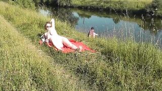 Wild beach. Sexy MILF Platinum naked sunbathing on river bank, random fisherman guy watches. Naked in public. Nude beach